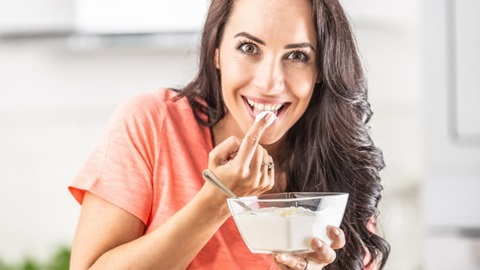 vrouw proeft haar zelfgemaakte yoghurt